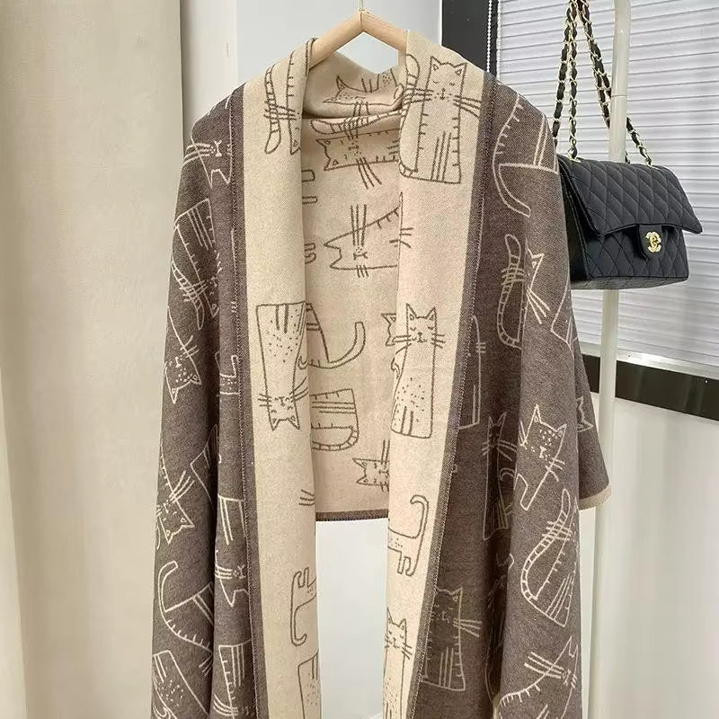 Scarf with cat pattern on a hanger next to a black handbag.
