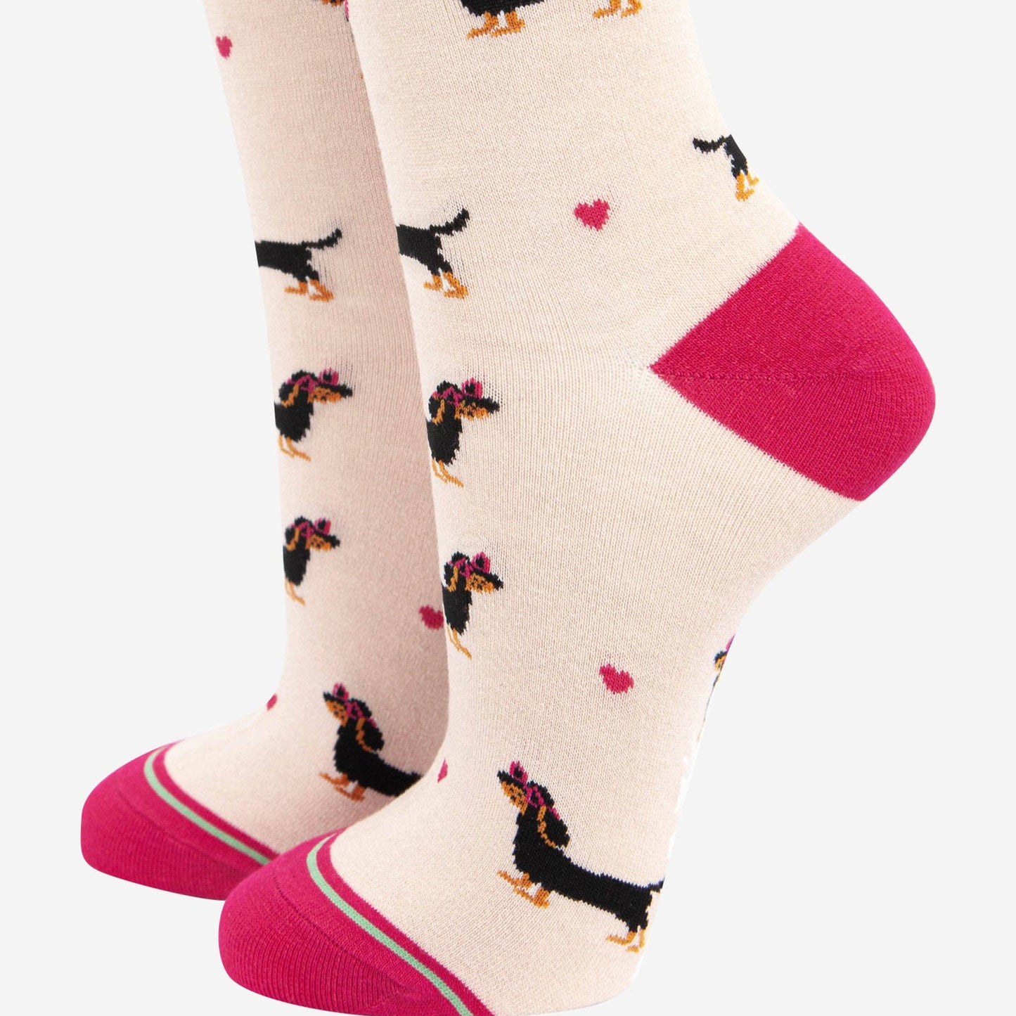 A pair of women's socks with a playful sausage dog wearing love heart sunglasses design, featuring a striped detail cuff in pink at the heel and toe.