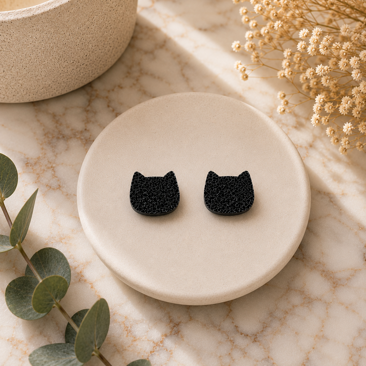 BlackGlitterCatFaceEarringsBenchtop.png