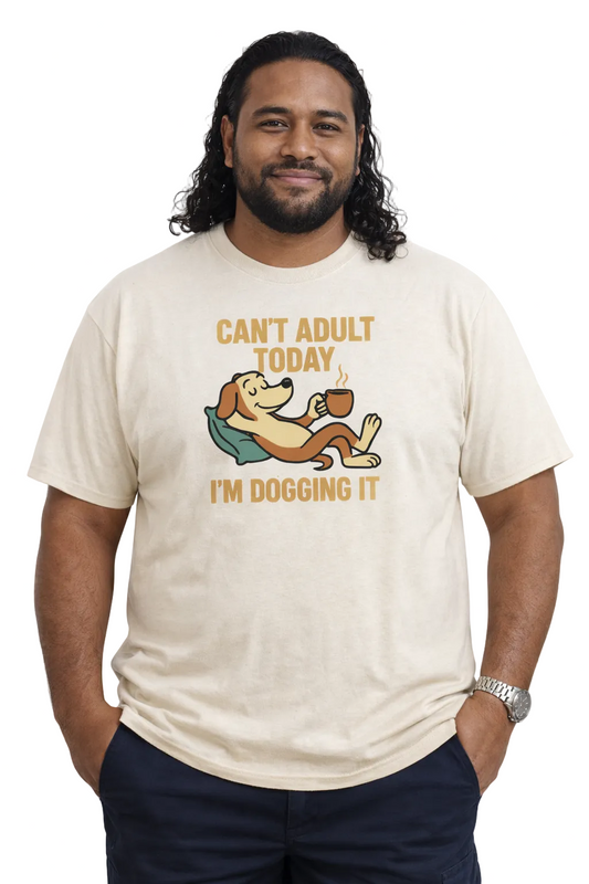 Man wearing a cream t-shirt with a graphic and text 'Can't Adult Today, I'm Dogging It' on a white background