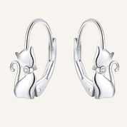 A pair of silver hoop earrings featuring a small cat silhouette charm on each earring, with a clear rhinestone at the center of the cat.