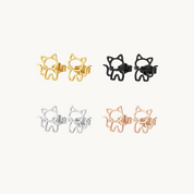 Set of cat-shaped earrings in gold, silver, and rose gold on a white background