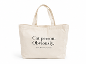 A natural canvas tote bag with black printed text reading 'Cat person. Obviously.