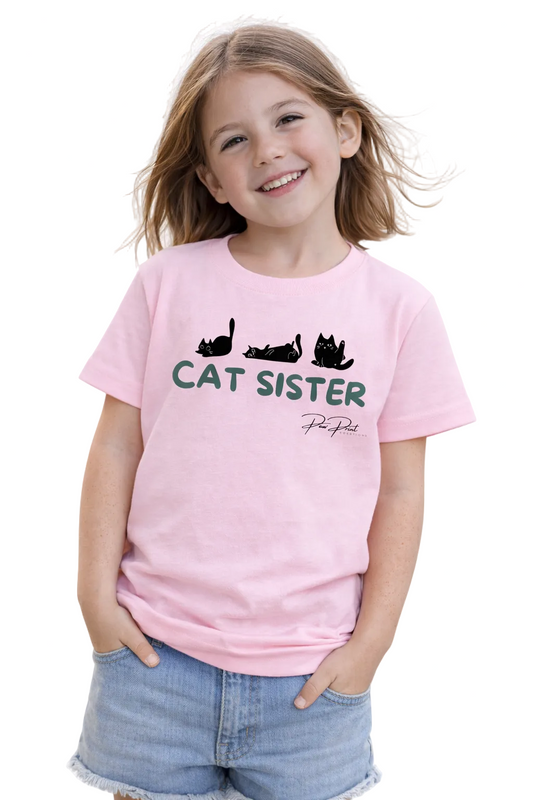 Child wearing a pink t-shirt with 'Cat Sister' text and cat illustrations on a white background