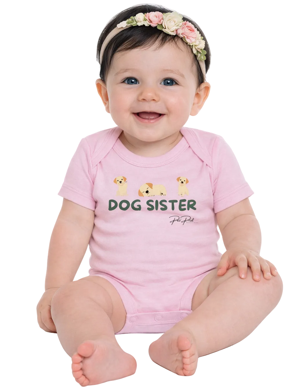 Baby wearing a pink 'Dog Sister' onesie with a floral headband on a white background
