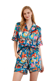 Woman wearing a colorful pajama set with animal print on a white background
