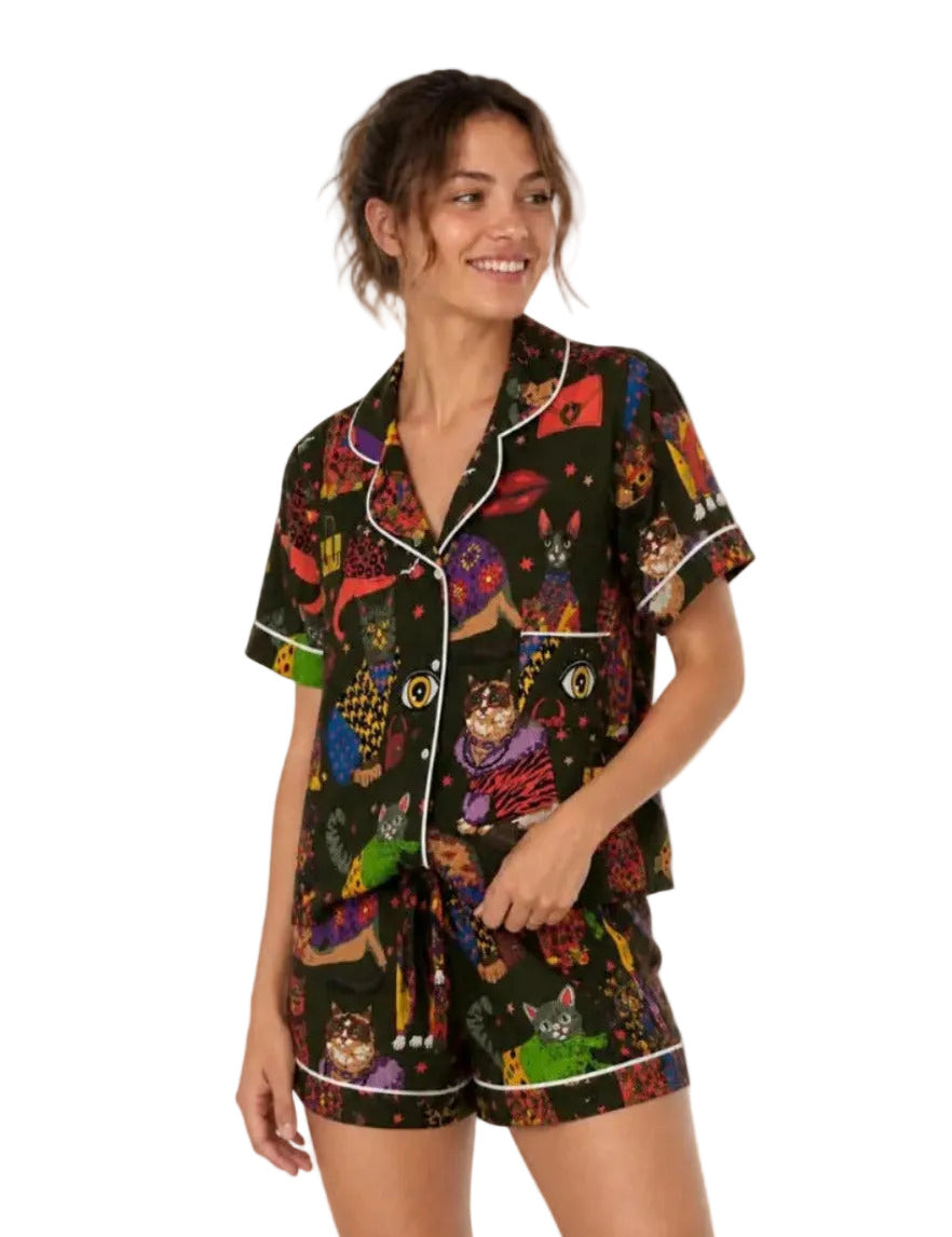 Woman wearing a colorful pajama set with dog pattern on a white background