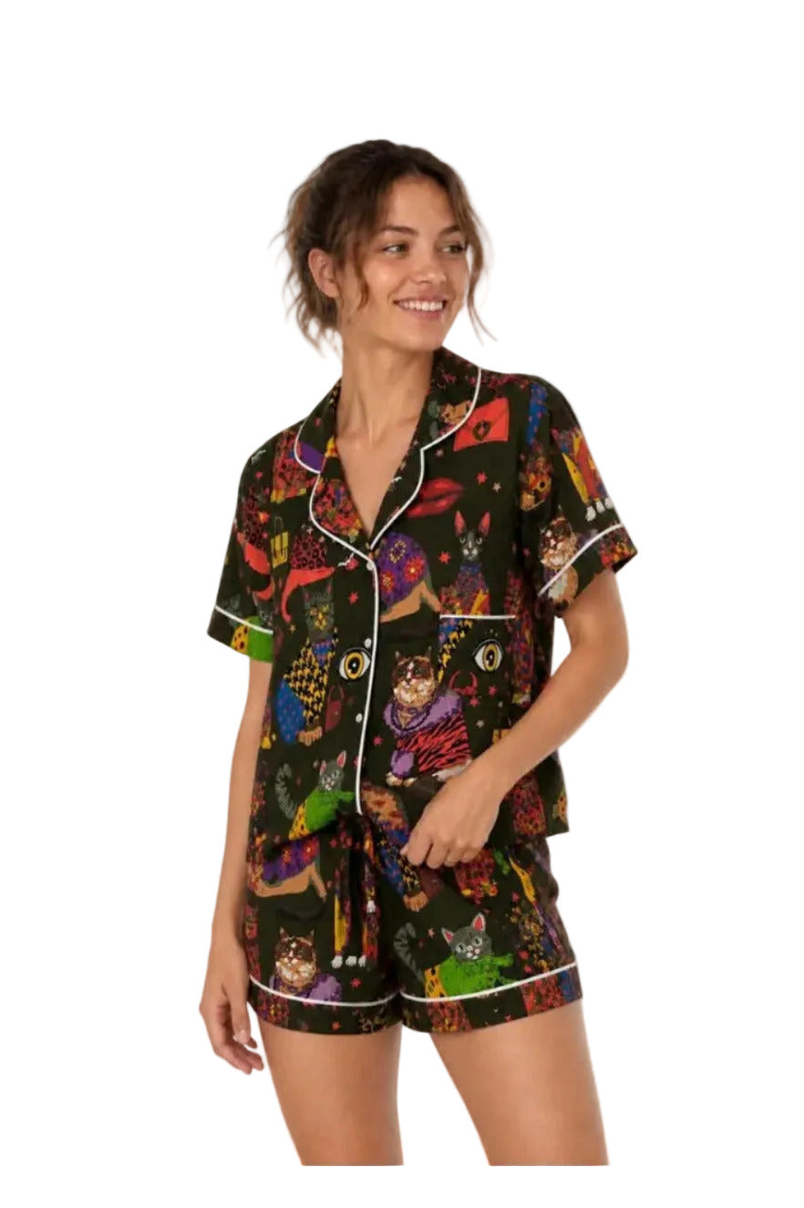 Woman wearing a colorful pajama set with dog pattern on a white background
