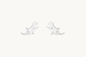 A pair of silver stud earrings shaped like sitting dogs, shown on a clean white background.