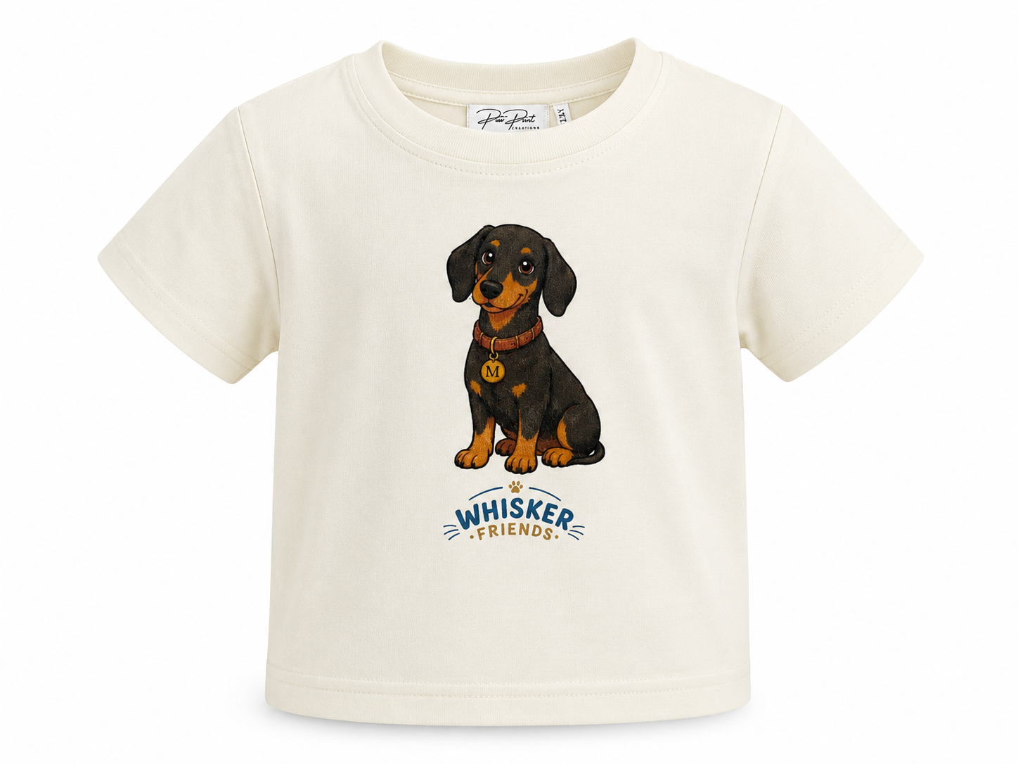 An off-white short-sleeve baby t-shirt featuring a cartoon illustration of a black and tan dachshund wearing a red collar with a gold badge, above the text 'WHISKER FRIENDS'.