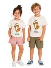 A young girl and a young boy modeling matching off-white graphic t-shirts with a cartoon cat and the text 'WHISKER FRIENDS. The girl is wearing pink shorts and white sneakers, and the boy is wearing olive green cargo shorts and blue sneakers, set against a plain white studio background.
