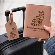 Brown leather passport holder with cat illustration and luggage tag, held over a suitcase.