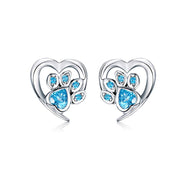 Heart-shaped earrings with paw design and blue gemstones on a white background