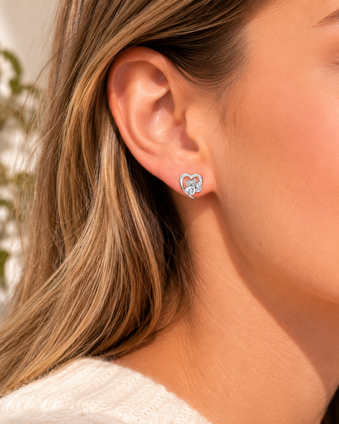 Close-up of a person wearing a silver earring with a butterfly design.