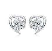 Heart-shaped earrings with paw design and clear gemstones on a white background