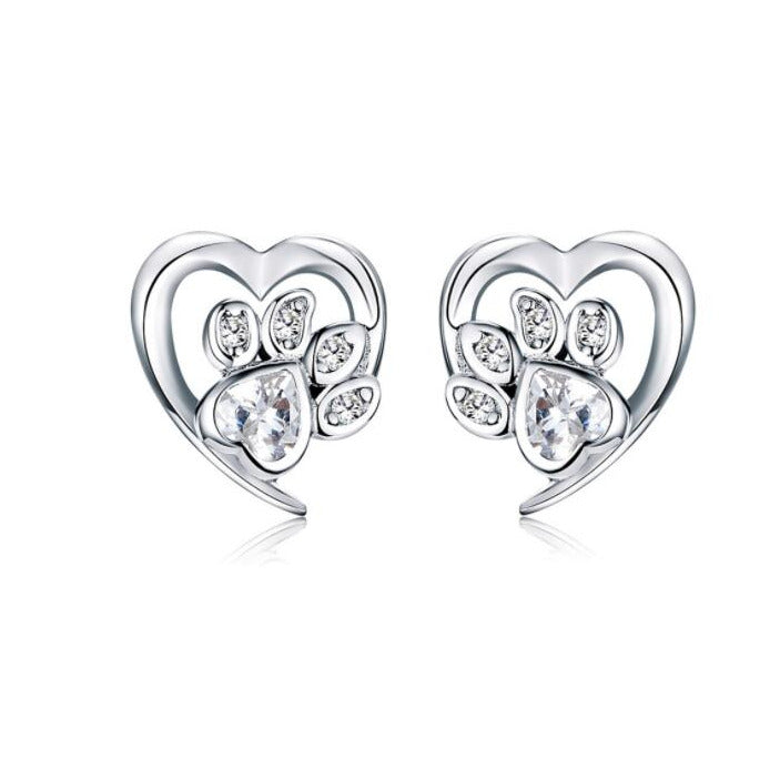 Heart-shaped earrings with paw design and clear gemstones on a white background