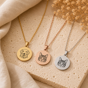 Three animal-themed necklaces on a textured surface with dried flowers.