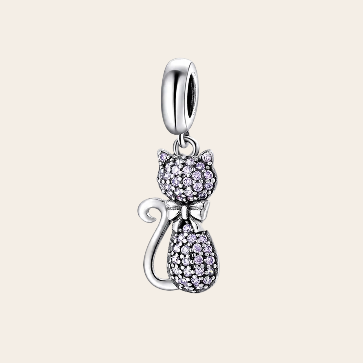 A silver cat-shaped charm pendant adorned with small clear pavé stones, featuring a silver bow and a polished silver bail at the top, shown on a white background with a soft reflection below.