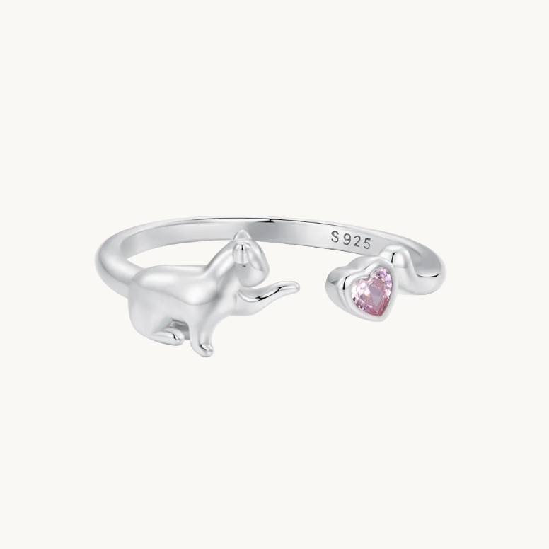 Silver ring with a unicorn design and pink heart-shaped gemstone on a white background