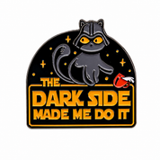 A novelty enamel pin featuring a black cat styled as Darth Vader with glowing yellow eyes, set against a black background with gold stars and the text 'THE DARK SIDE MADE ME DO IT' in gold lettering. A small red and white fist is visible on the right side of the text.