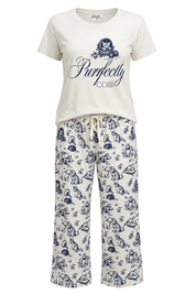 A two-piece pajama set from Purfectly Cosy featuring an off-white short-sleeve t-shirt with a navy blue graphic print and matching wide-leg pants with a navy blue dog pattern, shown against a plain white background.