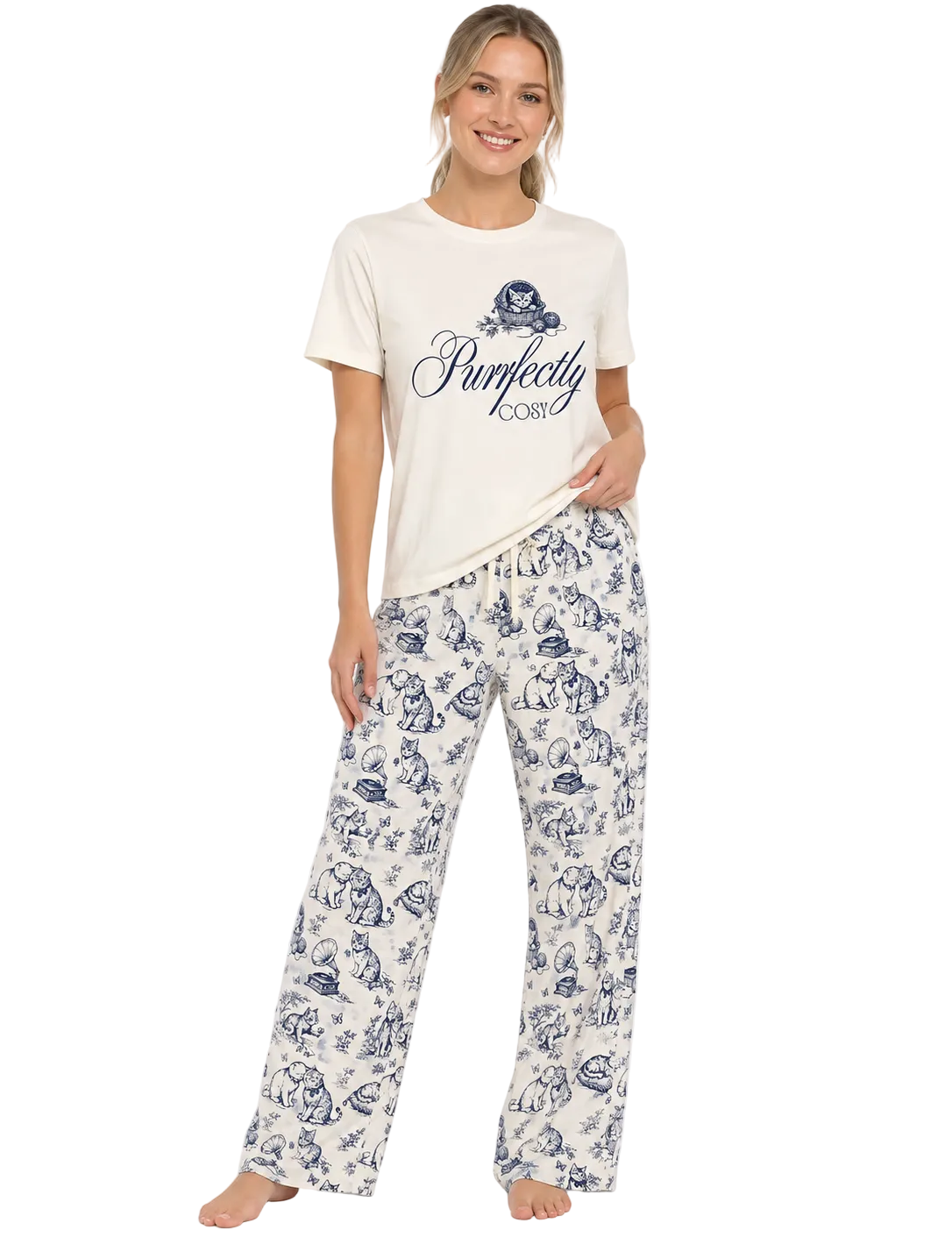 A woman modeling a two-piece pajama set consisting of an off-white t-shirt with a navy blue graphic print and matching wide-leg pants with a navy blue toile-style pattern, against a plain white background.