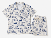 A two-piece pajama set featuring a short-sleeve button-front top and matching shorts in an off-white fabric with a blue toile-style dog pattern, laid flat on a light gray background.