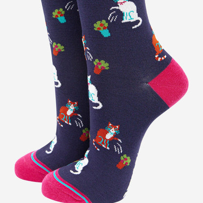 A pair of navy blue women's bamboo socks with a playful cat design, featuring pink toes and a floral pattern.