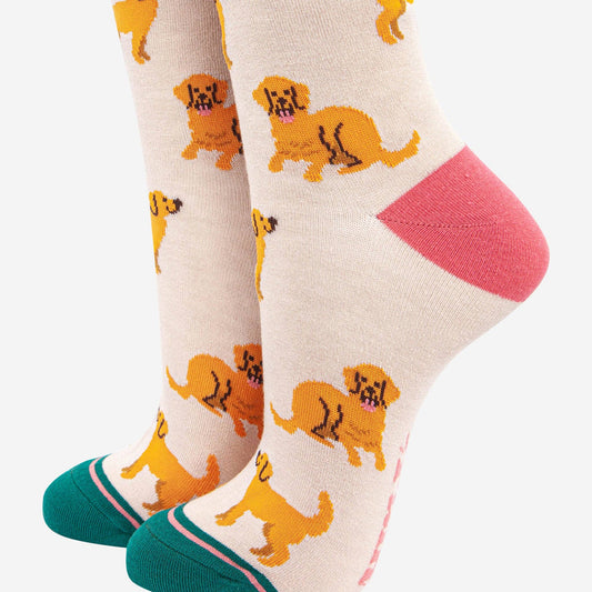 A pair of women's socks with a playful golden retriever design and a striped detail cuff.